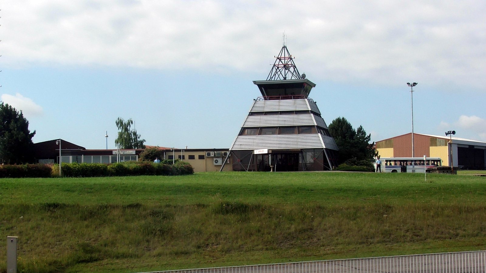 La tour de contrôle pyramidale de l'aéroport d'Épinal-Mirecourt, à Juvaincourt, au-dessus d'un talus herbeux